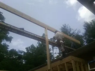 Carpenter setting a ridge beam over a new addition frame — Ice Dam Removal by Roofing Brothers in Gilbert