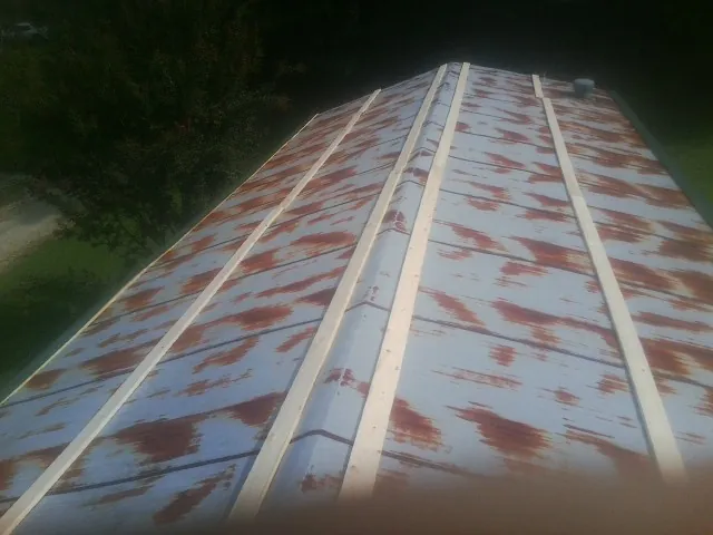Rusted metal roof panels with new wood purlins before replacement — Storm Damage Roof Repair in Gilbert by Roofing Brothers
